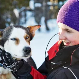 a person cuddling a husky